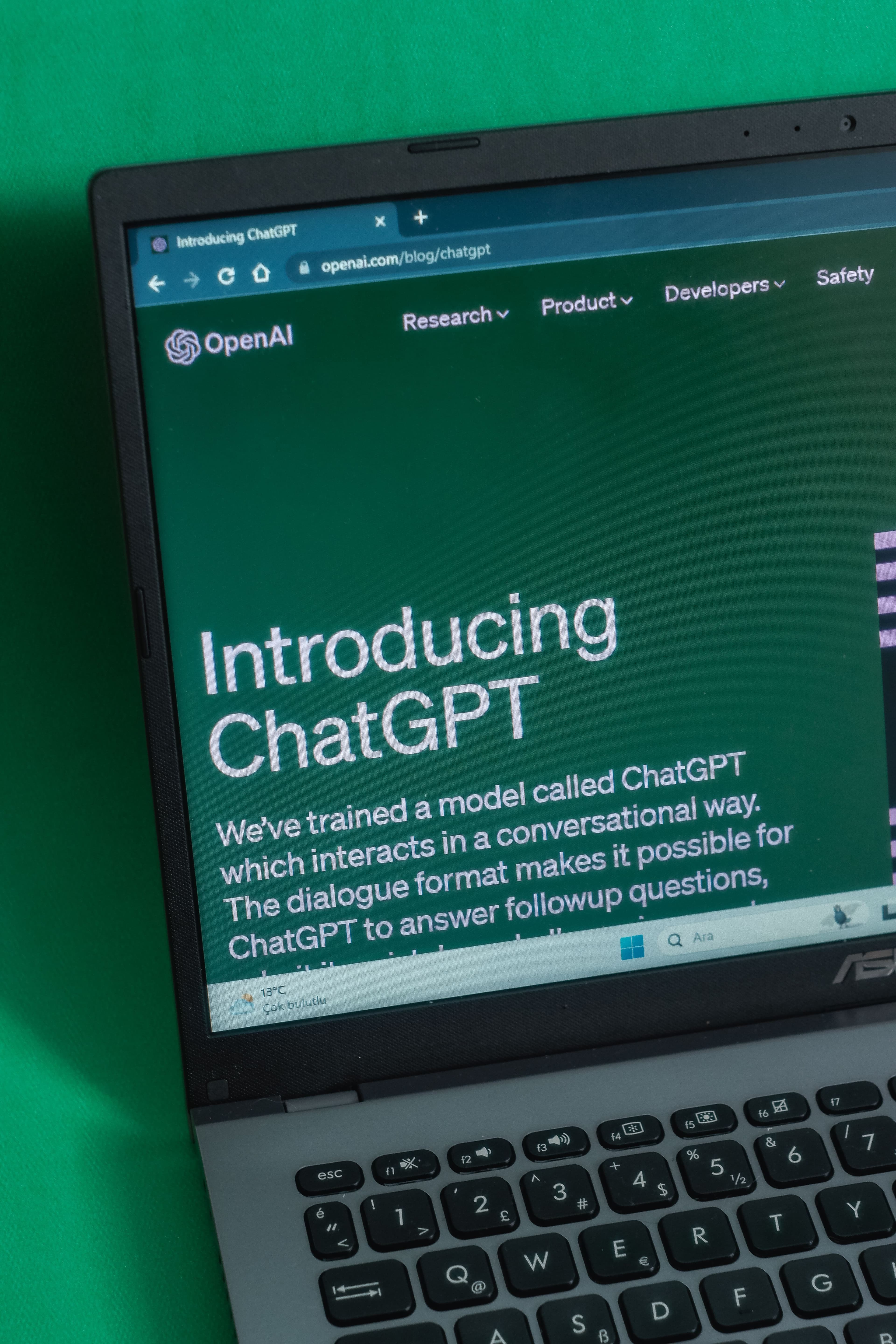 Laptop displaying the OpenAI “Introducing ChatGPT” webpage on screen.