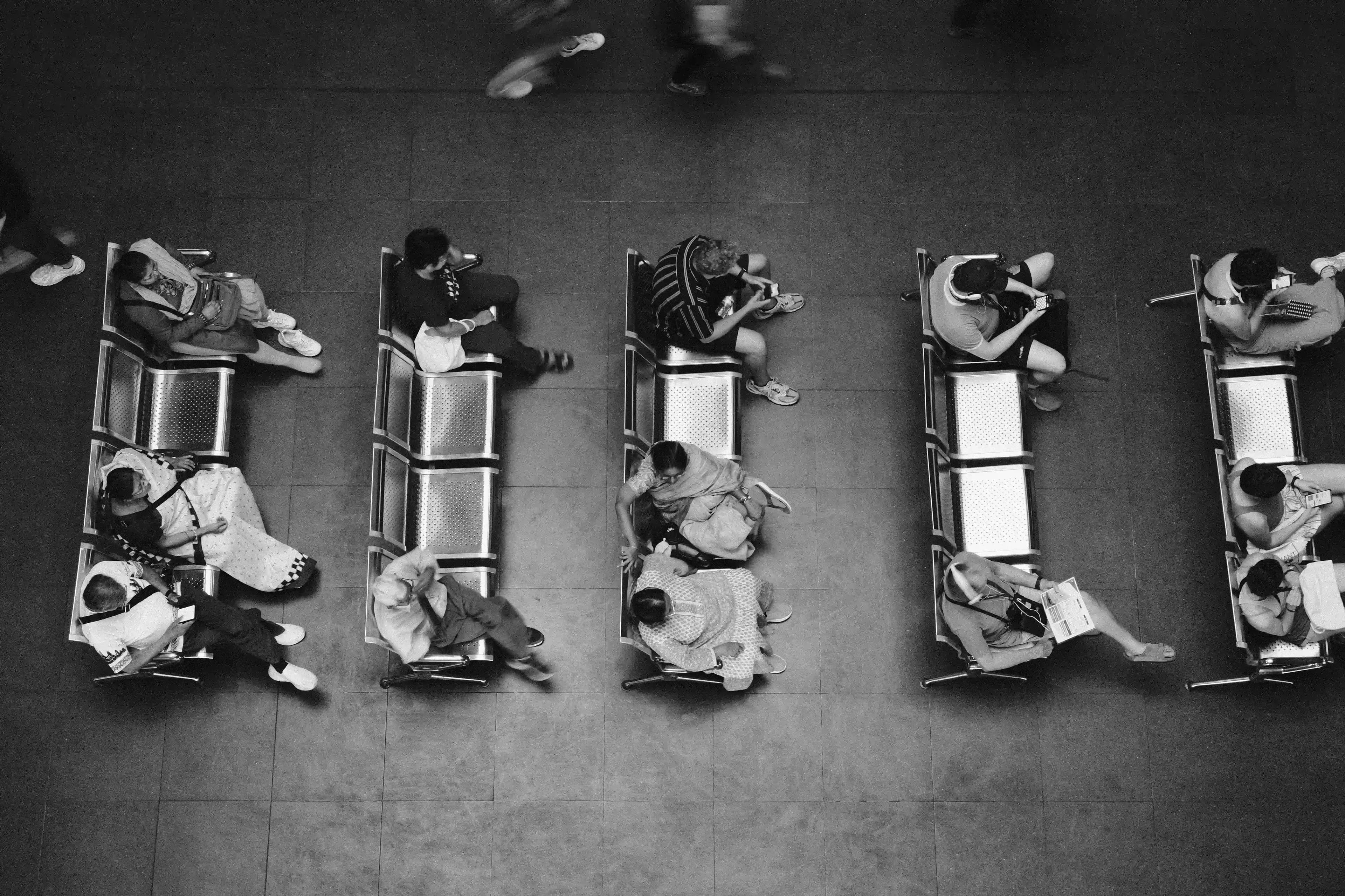 Black and white overhead photo of people waiting.